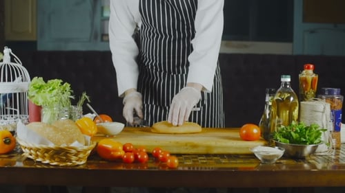 Chef Preparing Sandwich With Fresh Ingredients in Kitchen
