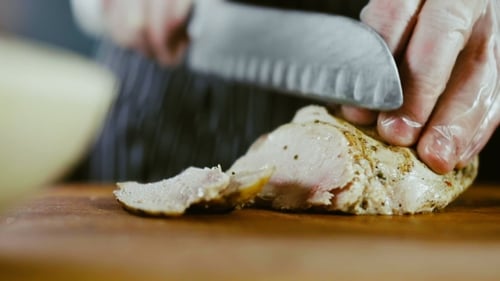 Chef Slices Cooked Chicken Breast With Sharp Knife