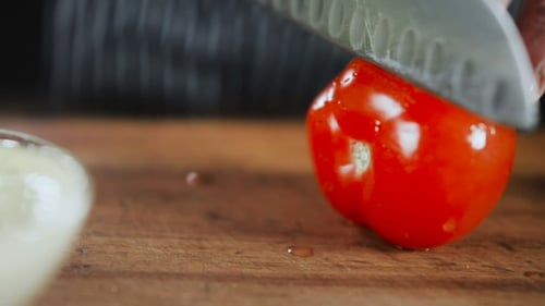 Tomato Being Sliced With Knife on Cutting Board