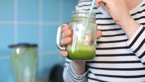 Female Tasting a Green Smoothie