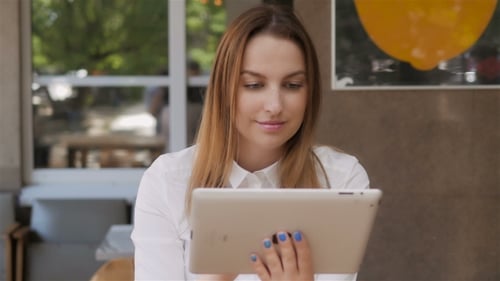 Young Pretty Business Woman Using Tablet PC On Lunch Break In An Outdoor Cafe