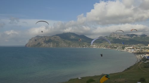 Paragliders Soaring over Ocean and Coastal City