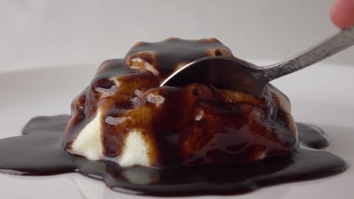 Ein Stück Pudding und Schokoladensauce mit einem Teelöffel nehmen Video