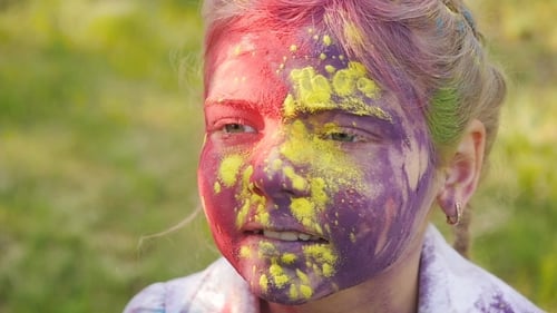 Portrait Of a Cute Girl Painted In The Colors Of Holi Festival.