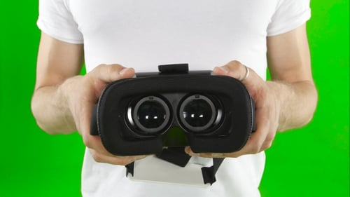 Adult Holding VR Glasses with Green Screen Background
