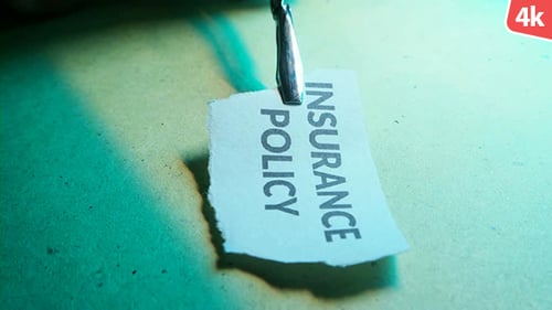 Insurance Policy Held in Tweezers, Close Up