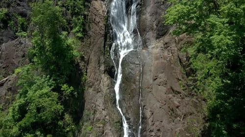 Drone shot pulling back from a waterfall in the forests of Costa Rica