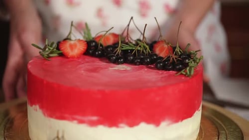 Primer plano del pastel, las manos del chef retuercen el postre en una bandeja de madera