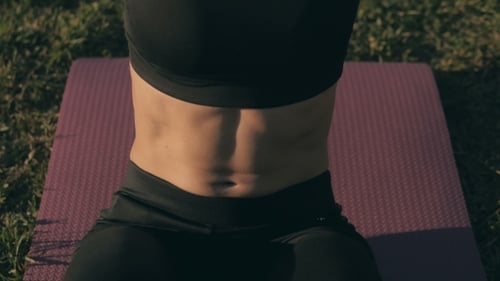 Sports Sexy Blonde Girl Model fait des exercices abdominaux à l'extérieur dans le parc