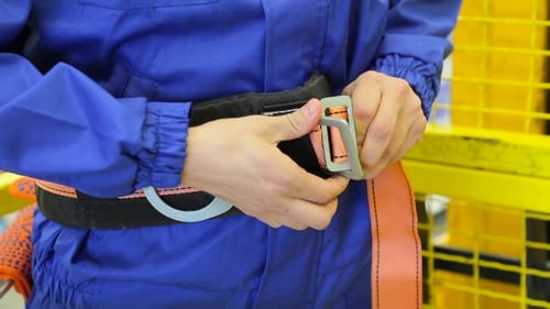 Un homme attache une ceinture de sécurité dans un entrepôt