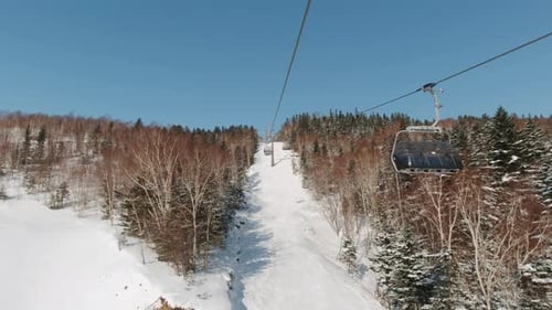 Riding on Ski Lift Above the Slopes in the Morning