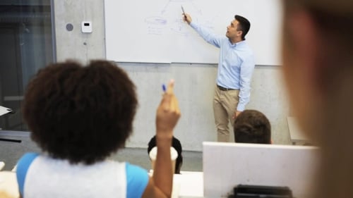 Teacher giving lecture in classroom with students