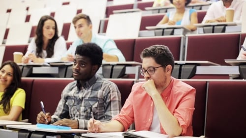 Group Of Students With Notebooks In Lecture Hall