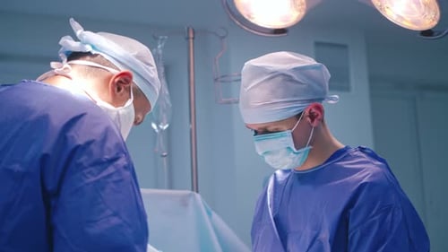 Modern Hospital Operating Room. In the hospital operating room diverse team of professional surgeons