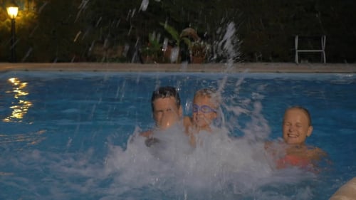 Happy Family Splashing Water In The Pool