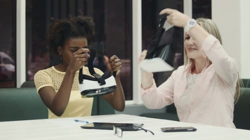 Women Explore Virtual Reality Headsets Together Indoors