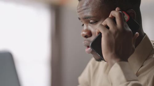 Afroamerican Businessman is Talking By Cellphone From Home or Working Office Closeup View of Face of