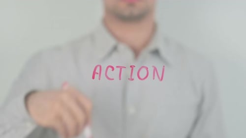 Man Writes the Word Action in Pink Marker