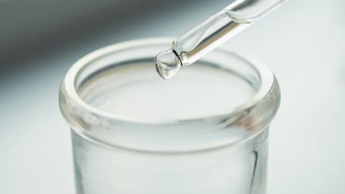 Dropping Liquid into Test Tube in Laboratory