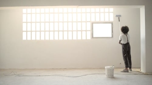 Person Painting White Wall with Roller Indoors