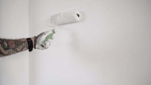 Man Painting Wall with Paint Roller