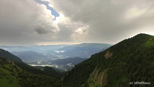 Aerial View of Mountain Range Under Dramatic Clouds