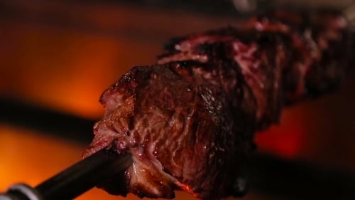 Roasted Meat Rotating on Skewer, Close-Up