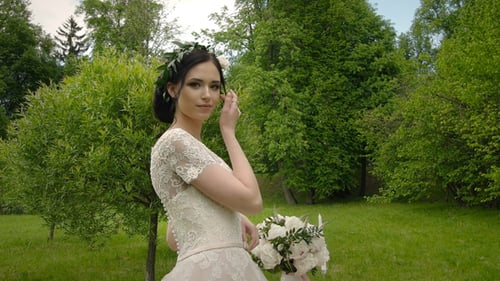 Elegant Bride Poses in Beautiful Green Park Setting