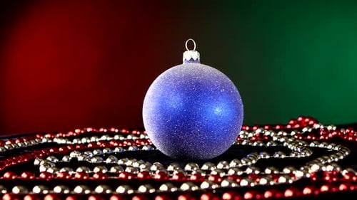 Shiny Blue Toy for Christmas or New Year and Beads, Rotation, on Red and Green