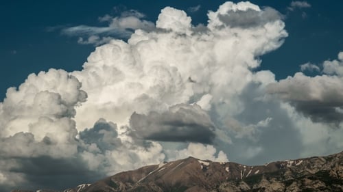 Von großen Wolken, die sich über Berg bewegen