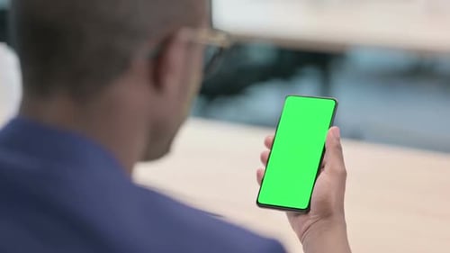 Rear View of Young Businessman Using Smartphone with Chroma Screen