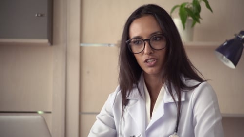 Young Woman Doctor Speaking Via Teleconference