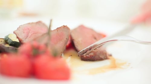 Steak Being Cut on a Plate with Vegetables