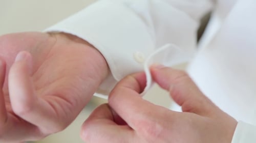Man Buttons Cuffs On Shirt