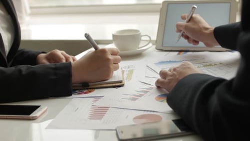 Business People Reviewing Financial Data At Desk