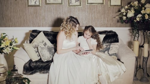 Woman and Child in Formal Dresses Look at Tablet