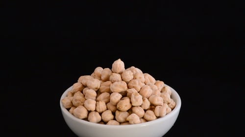 Bowl of Chickpeas Rotating on Black Background
