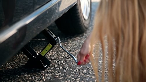 View Of Woman's Arm Jacking Up Her Car