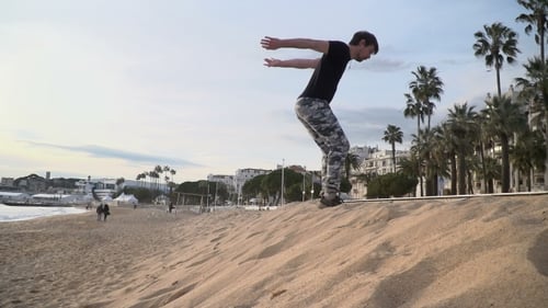 Young Man Doing Acrobatic Tricks On The Beach.