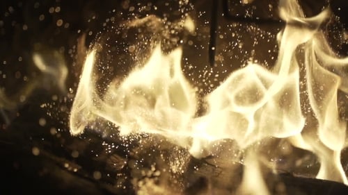 Golden Flames Flickering on Burning Logs at Night