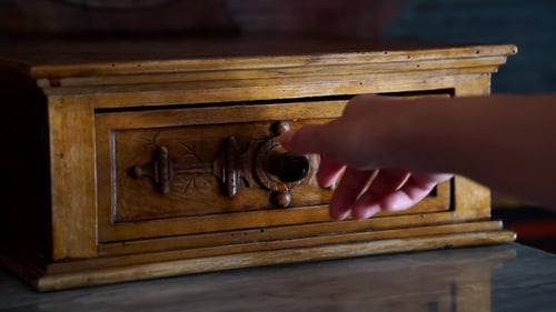 Hand Opens Ornate Wooden Drawer in Rustic Box