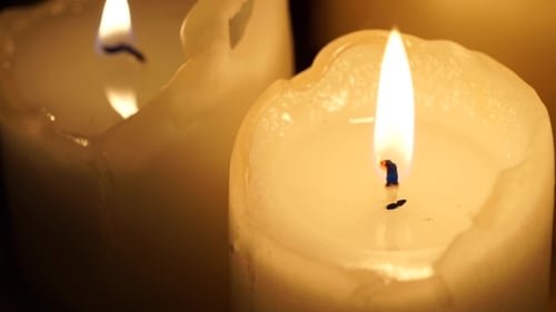 Close Up of White Candles Burning in Dark