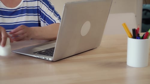 Adult Taking Pills with Water Near Laptop