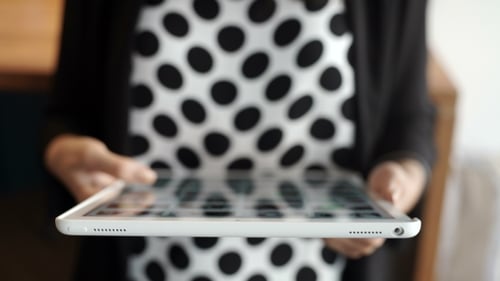 Jovem sorridente usando as mãos de um tablet digital