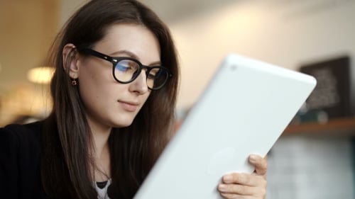Woman Sits At a Table At a Restaurant. Carried a Tablet With Access To Internet
