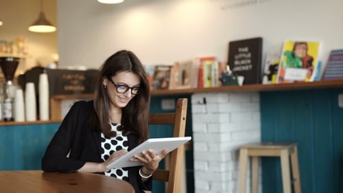 Woman Sits At a Table At a Restaurant. Carried a Tablet With Access To Internet