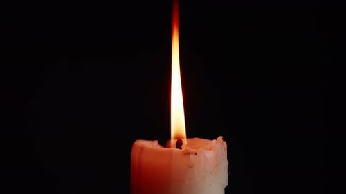 The showcases of colorful single candlelight on black background with the effect of light and slow m