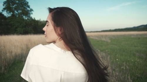 Woman with Long Hair Walking in Field