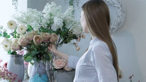 Une fleuriste organise des fleurs dans des vases au magasin de fleurs