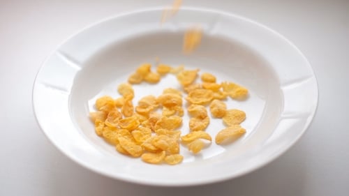 Corn Flakes Filling a White Bowl